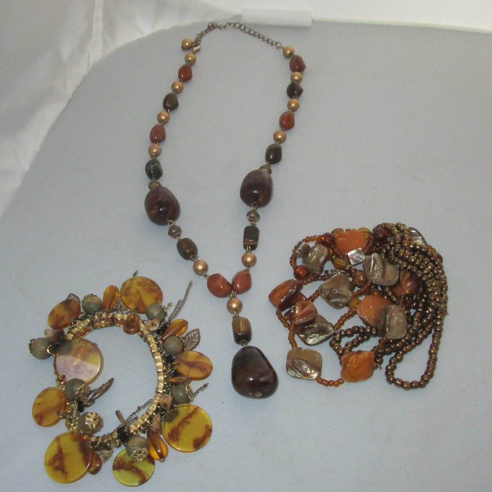 One necklace and two elastic style bracelets in browns gold